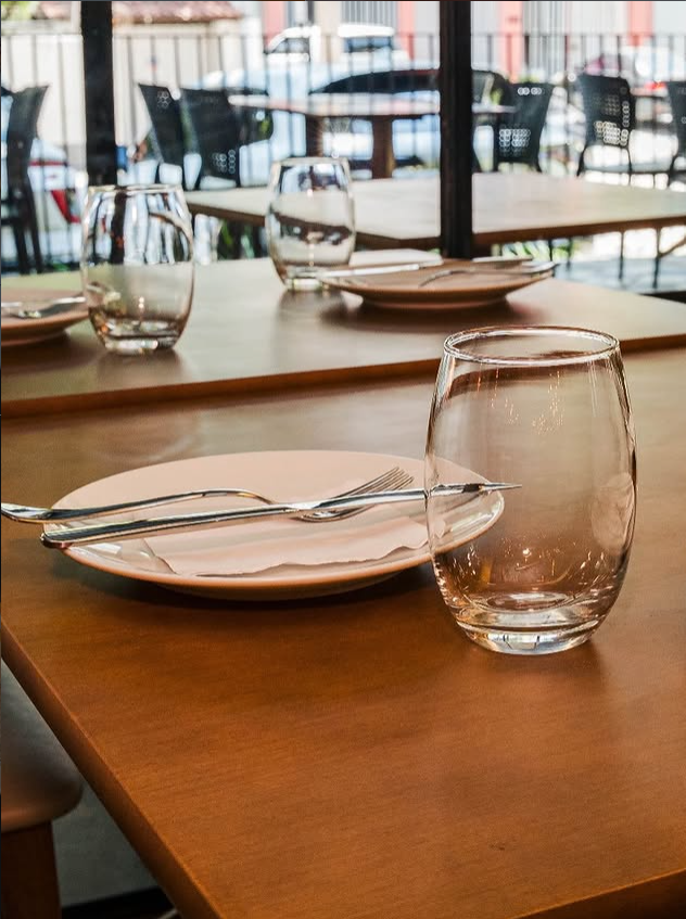 Mise en place com louças e taças sobre mesa de madeira