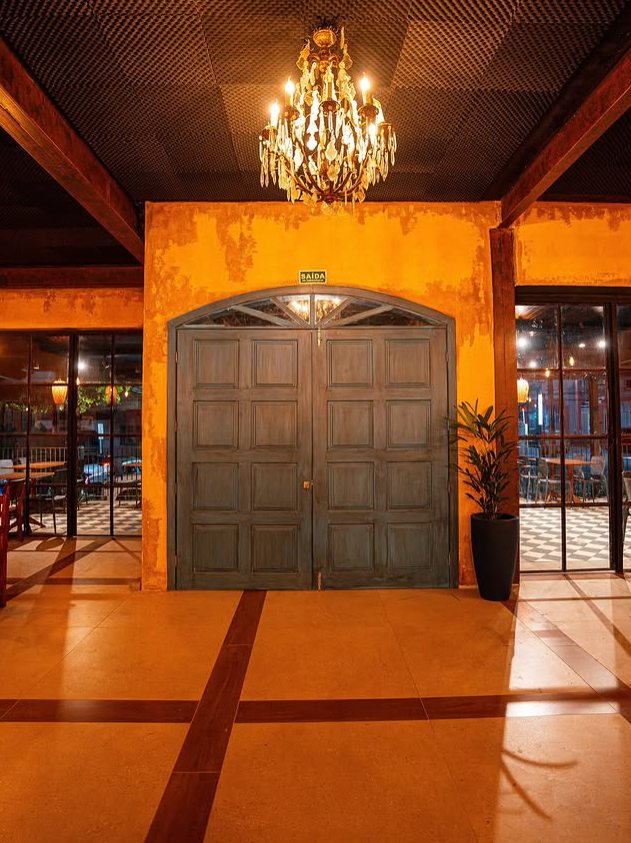 Hall de entrada com lustre de cristal e portas em madeira